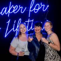 Philly poses with two grads in front of Laker for a Lifetime sign